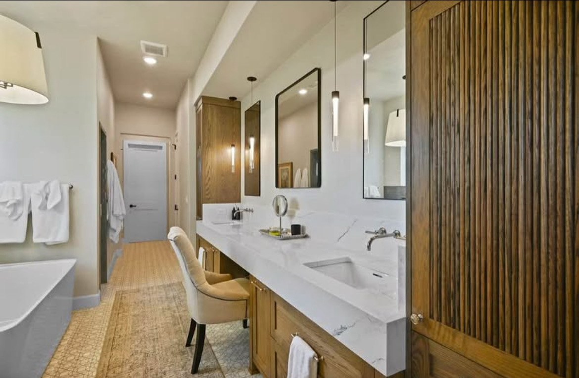 Primary bath with marble vanity and fluted wood feature wall