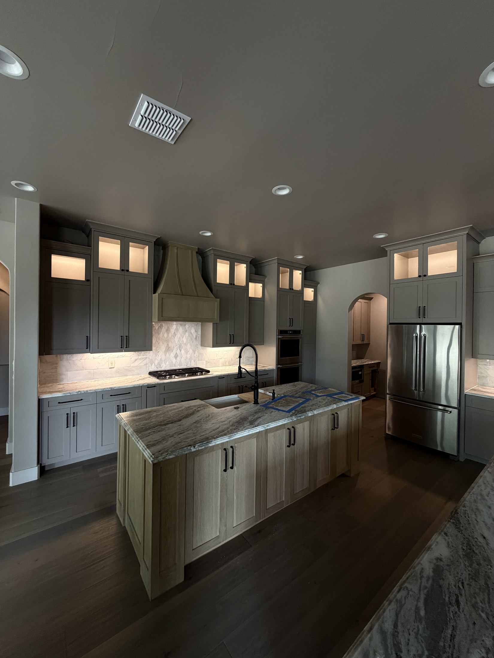 Kitchen with custom hood and stone waterfall island